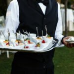 Waiter carries plate with tasty snacks